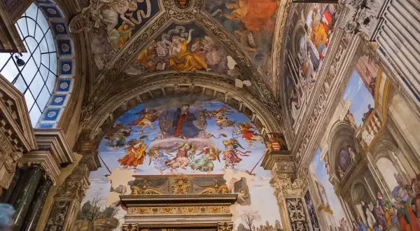 Affreschi celestiali adornano la volta di una chiesa a Roma, con angeli e figure bibliche che danzano tra nuvole e architetture dipinte.