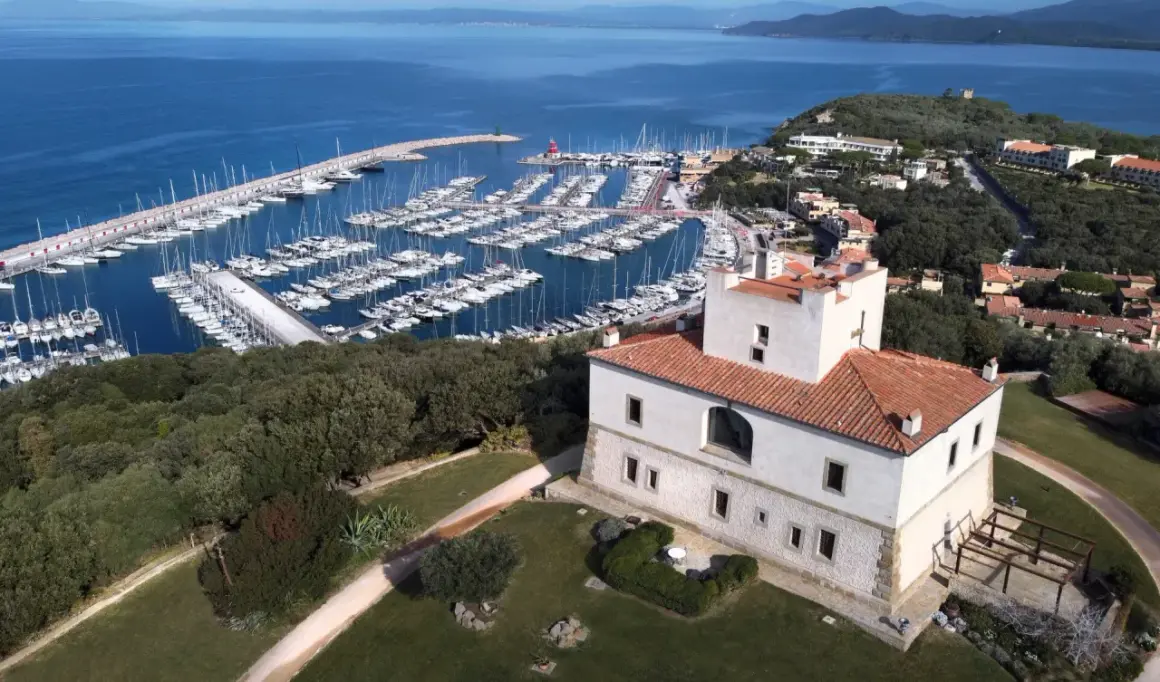 Punta Ala: un castello bianco con tetto rosso domina un porto turistico pieno di barche e il mare blu. Cosa vedere in questo luogo incantevole.