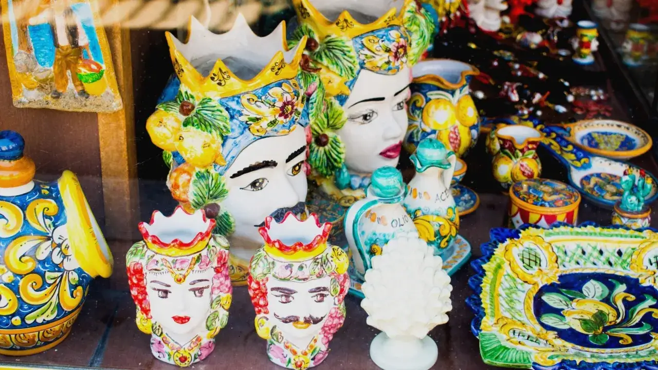 Ceramiche siciliane con teste di moro, vasi e piatti decorati, un'esplosione di colori che evoca il fascino di Palermo.