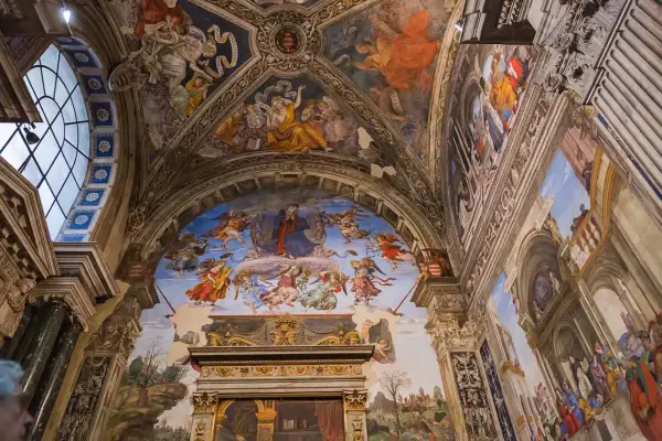 Affreschi celestiali adornano la volta di una chiesa a Roma, con angeli e figure bibliche che danzano tra nuvole e architetture dipinte.